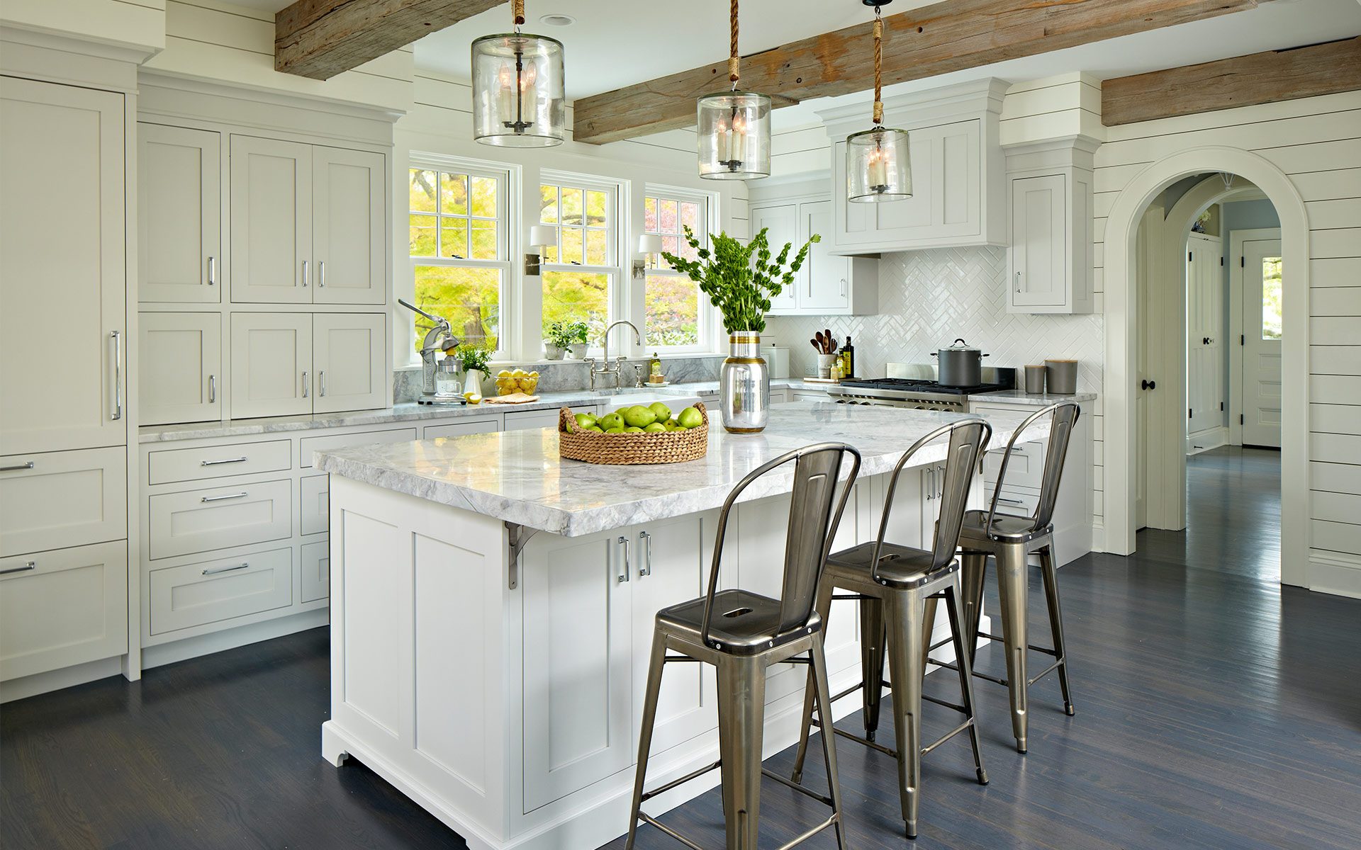 Contemporary kitchen designed by DEANE inc with custom cabinetry, custom countertops, wooden beams, and modern accents.