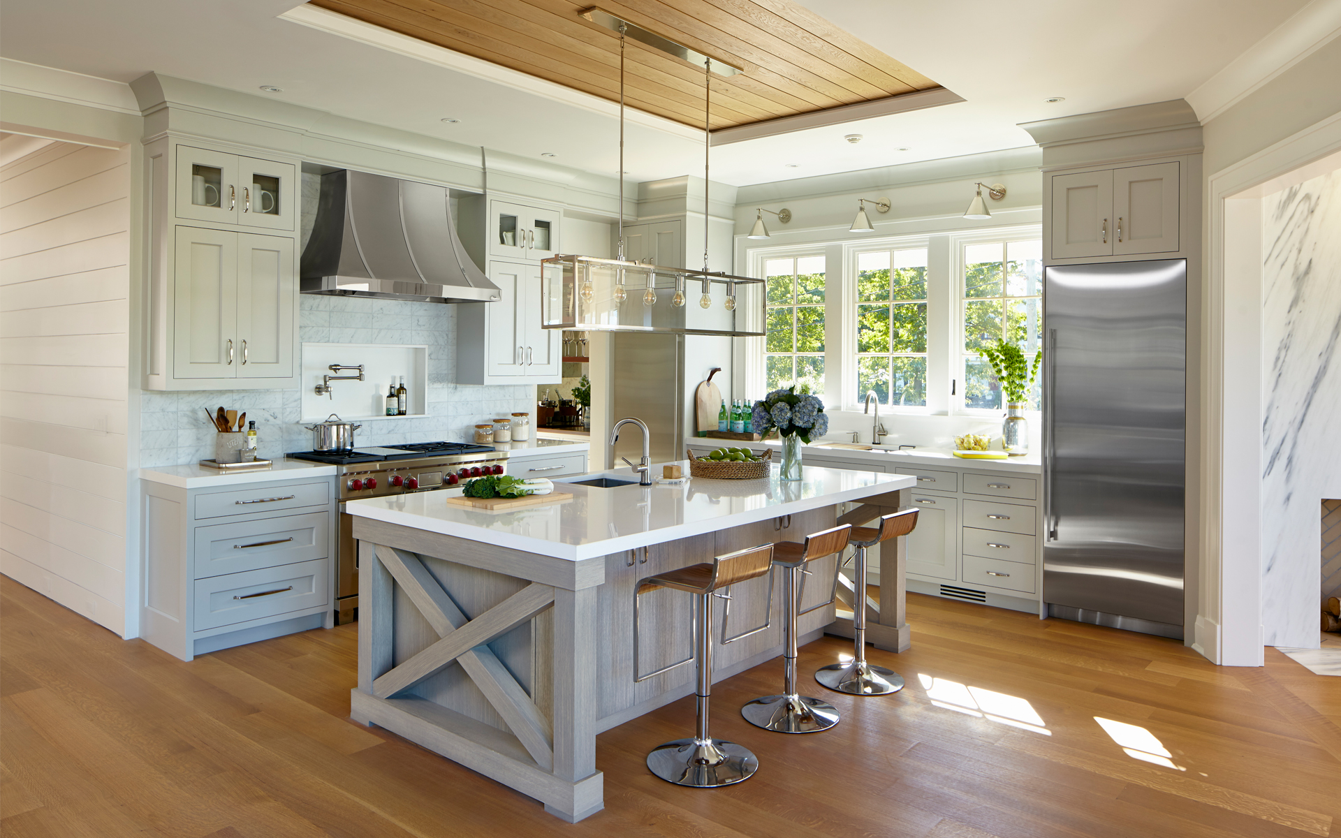DEANE Inc kitchen designed with custom cabinetry and a breakfast bar with countertop stools.